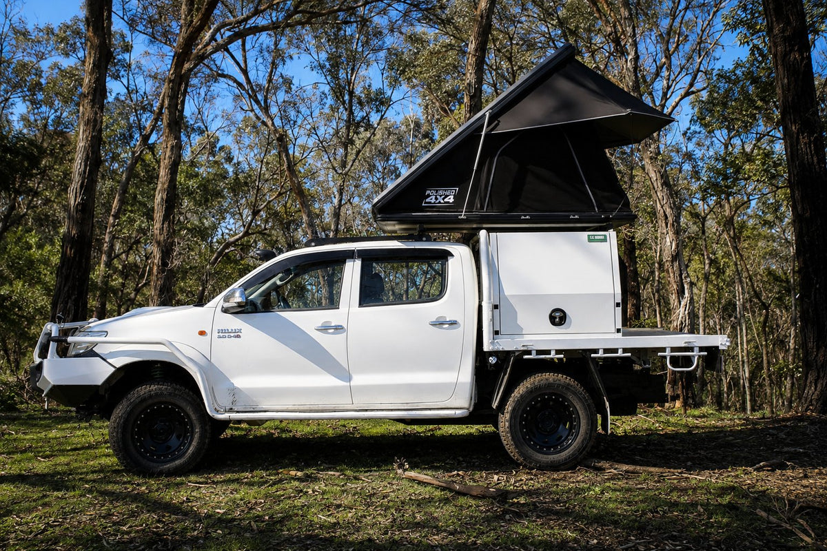 Polished T1 hardshell rooftop tent open on a white Toyota HiLux in Victorian bushland